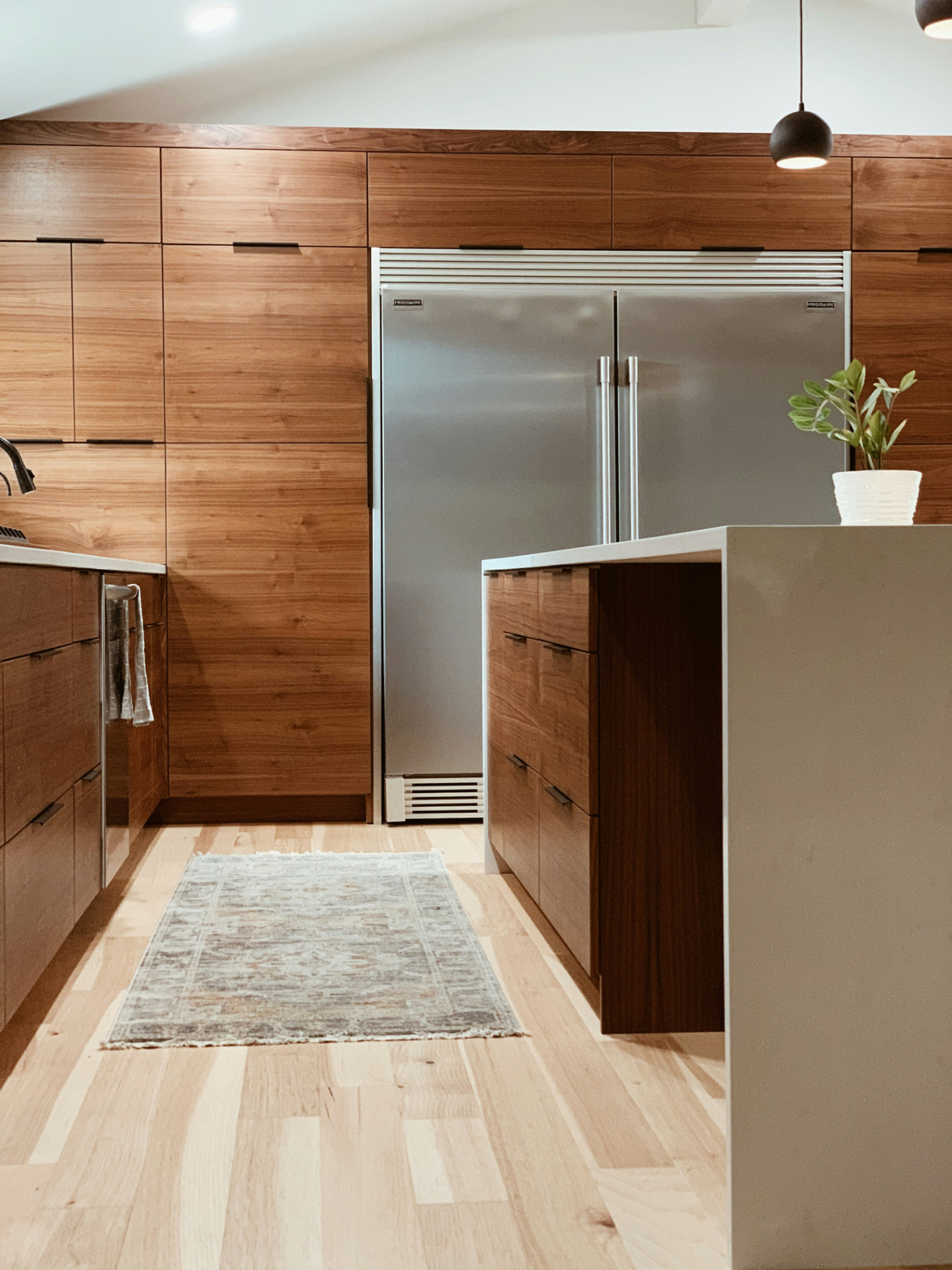 Floor-to-ceiling walnut custom kitchen cabinetry with integrated appliance panels